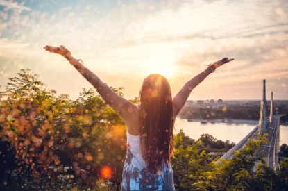 woman with arms outstretched at sunrise