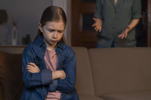 sad child being chastised by adult