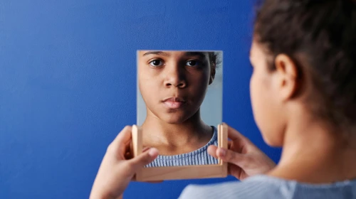 young woman looking in mirror