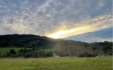 sun setting behind a mountain