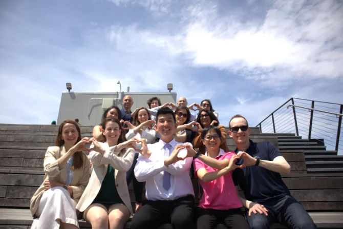 smiling group of people making hearts with hands