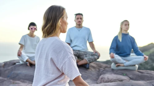 people meditating on rock